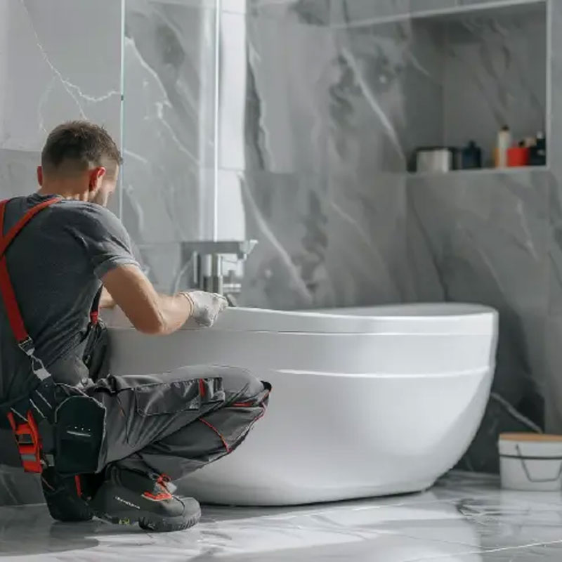 man repairing a tub