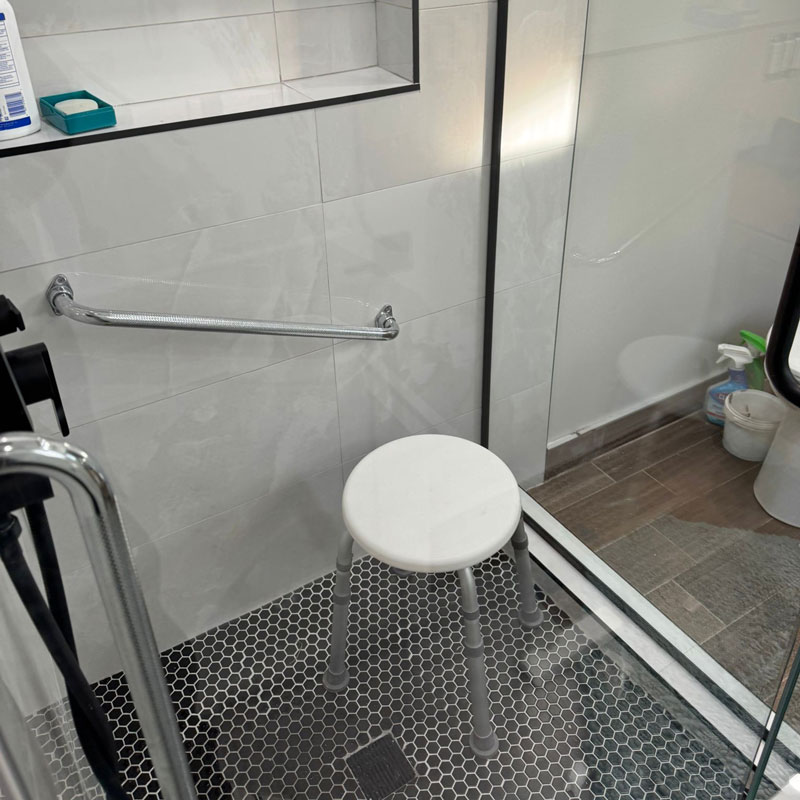 a handicap shower with handles and stools